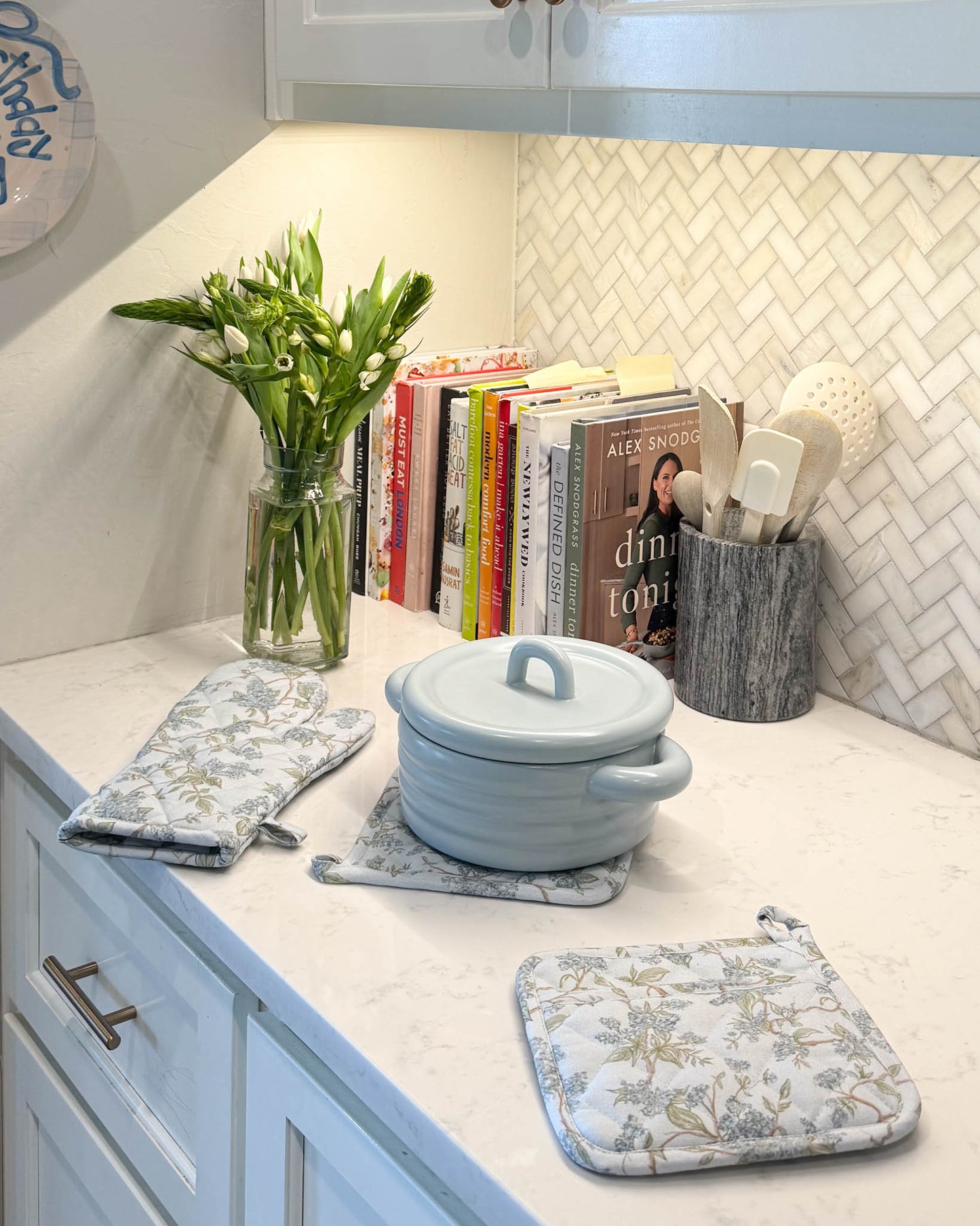 Blue floral matching oven mitts and pot holders in chic, elegant kitchen.