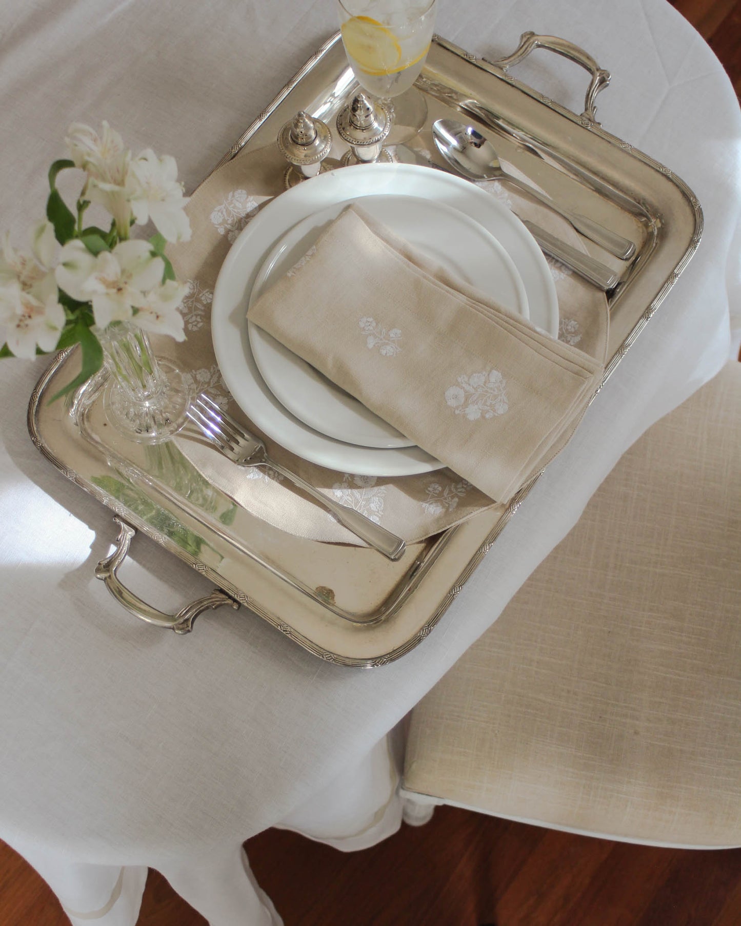 Sustainable napkins made from 100% organic cotton, featuring delicate white floral embroidery on a neutral beige background.