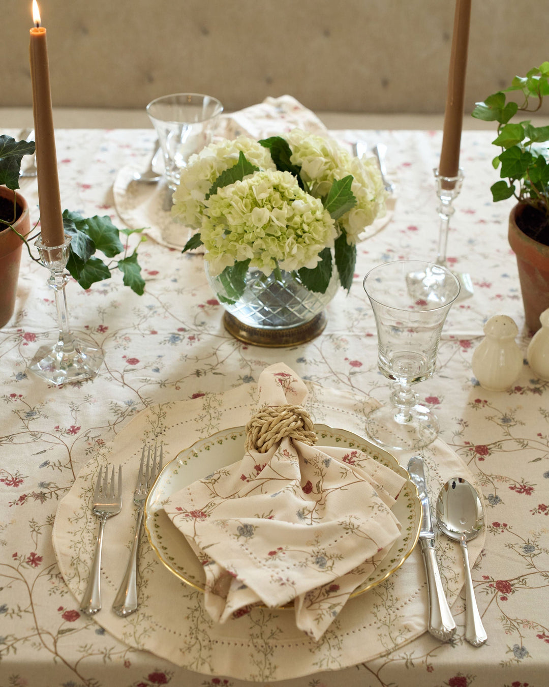 Antique-inspired floral tablecloth with cream, green, red, pink, yellow, and blue details for elegant Easter and spring table settings.