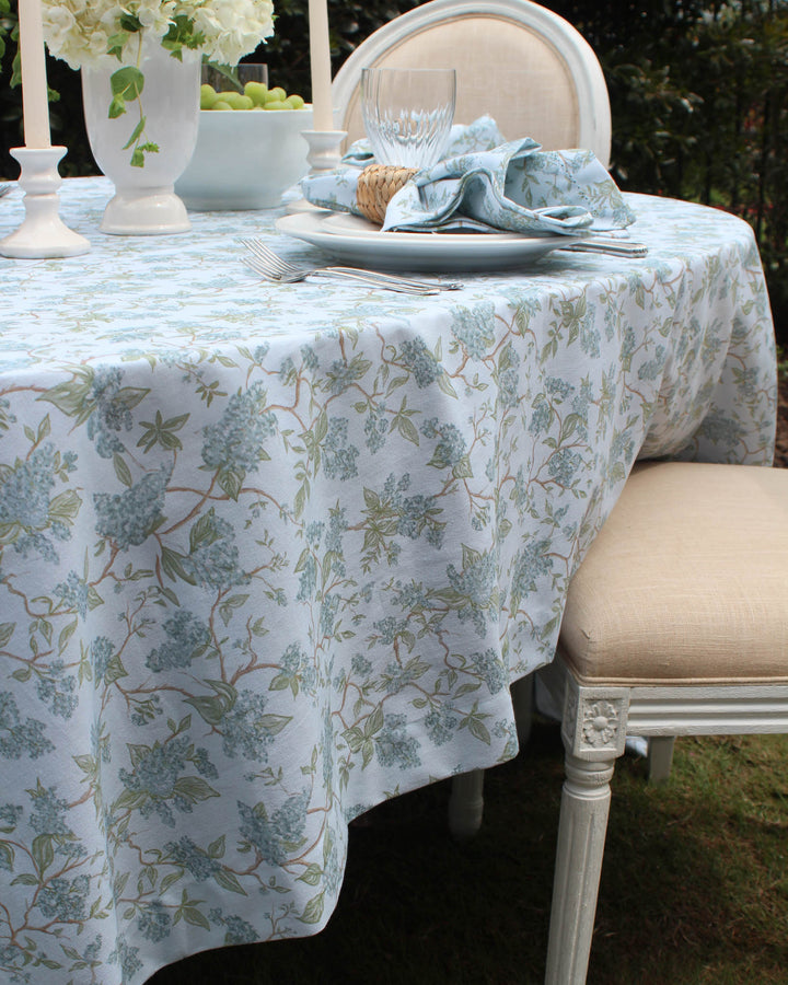 Chinoiserie floral cotton tablecloth with blue and green botanical vines, designed for spring weddings, Easter entertaining, and garden party tables. This rectangular  cotton tablecloth is dyed using non-toxic methods and handcrafted in India. Designed in Charleston, it brings French country elegance and grand millennial charm to rehearsal dinners, Mother’s Day brunch, and farmhouse table settings.