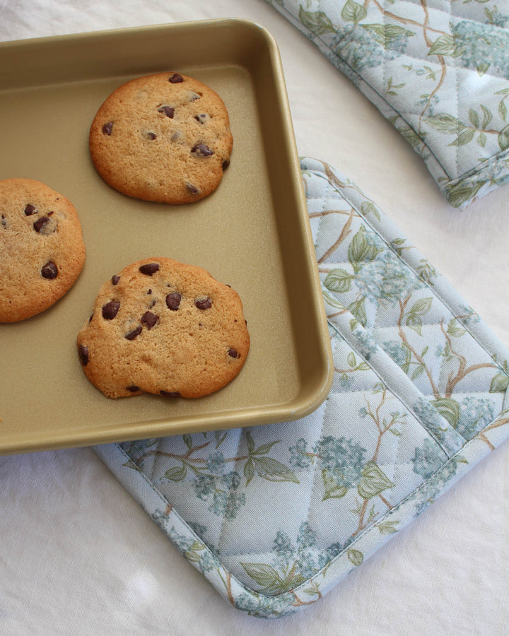 Cotton pot holders featuring a soft blue hydrangea watercolor floral design for everyday kitchen use.