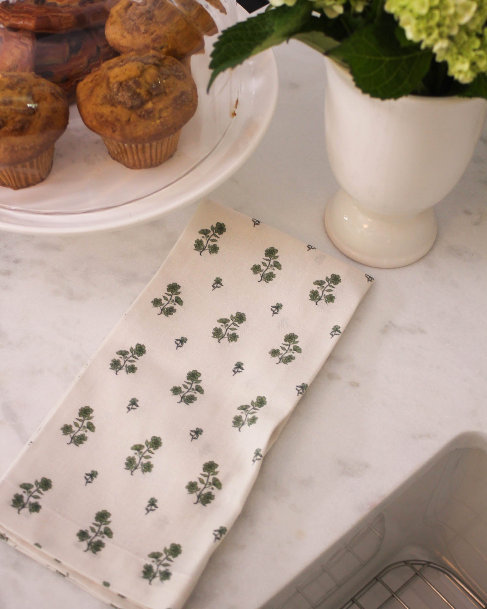 Green flower organic cotton tea towel for Thanksgiving hosting. Hand-drawn floral, hanging loop. Perfect for holiday baking, dishes, gift baskets. Made ethically.