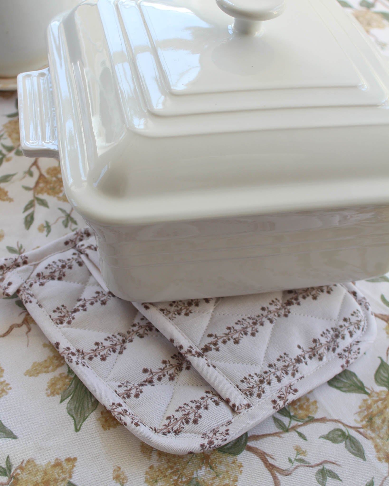 Brown stripe pot holder on yellow floral tablecloth