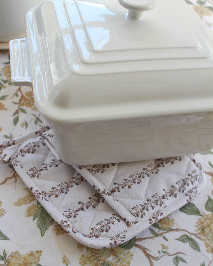 Featuring a warm chestnut brown floral stripe print, these quilted potholders are a must-have for grand millennial decor. This set of 2 woven potholders is made from premium cotton with recycled insulation for safe kitchen use. Each 8x8 square potholder has a loop for easy hanging. Use them as quilted trivets or floral hot pads during Easter baking. These make a wonderful Mother's Day gift for mom or grandma gift, offering a practical and beautiful addition to any spring kitchen set.