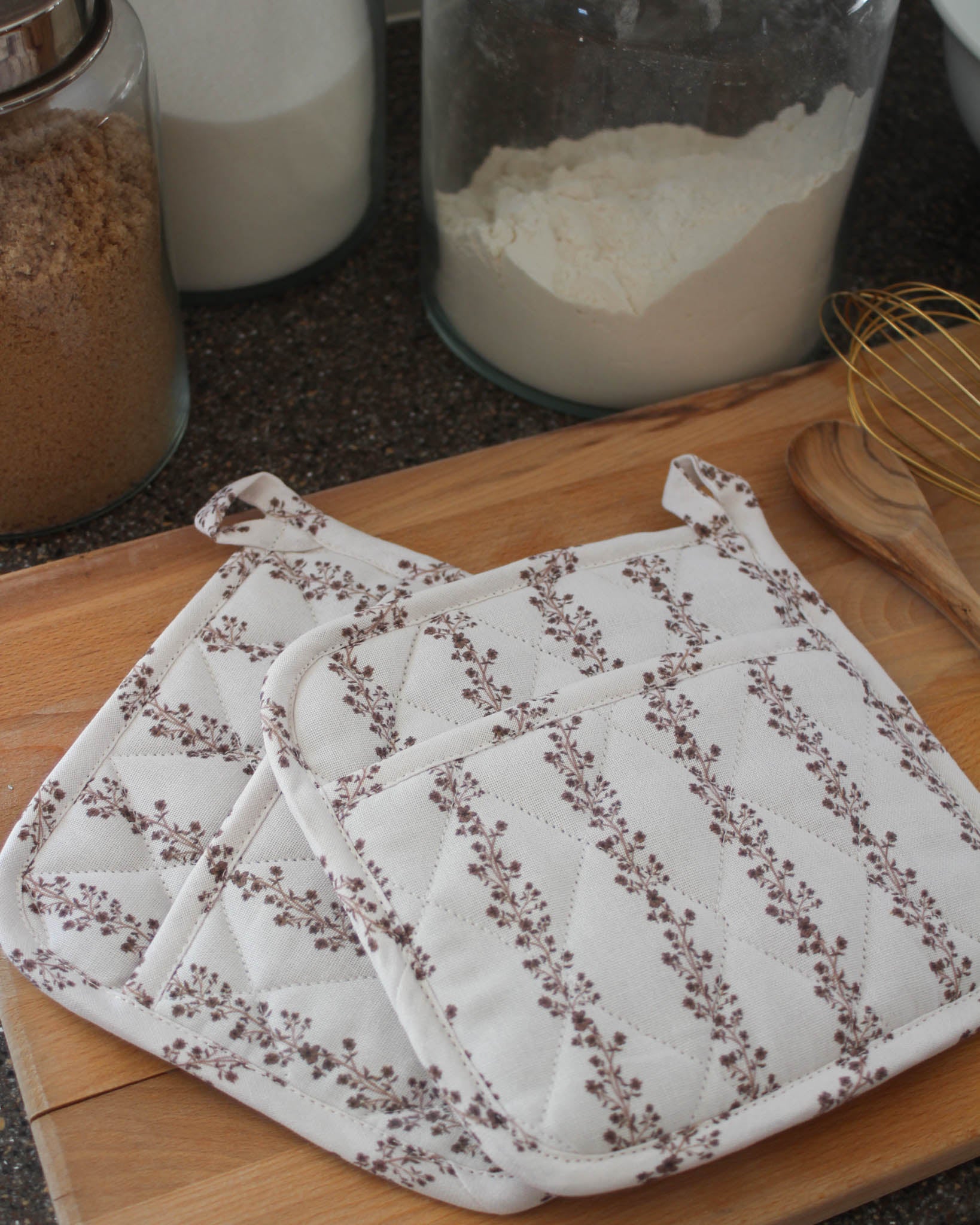Set of two quilted pot holders with brown floral pattern, perfect for hostess gifts and holiday gifting.