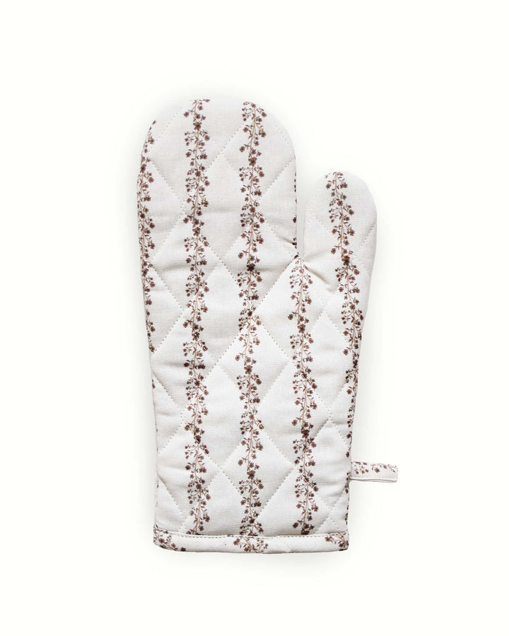 A pair of quilted brown floral oven mitts that fit perfectly into a traditional farmhouse or rustic kitchen. The vertical botanical stripe pattern offers a cozy, lived-in feel reminiscent of vintage textiles. Made from durable 100%  cotton, these long kitchen gloves are built for daily use. The heat-resistant filling ensures hands stay safe while handling hot cast iron or stoneware, blending heritage design with modern functionality.