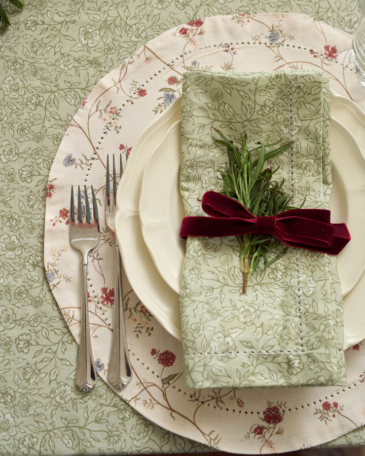 Decorative floral placemats in moss green, brown, and brick red for a beautiful holiday tablescape and Christmas gatherings.