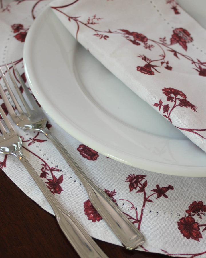 Classic round placemats with hand-illustrated floral design for a warm, festive table.