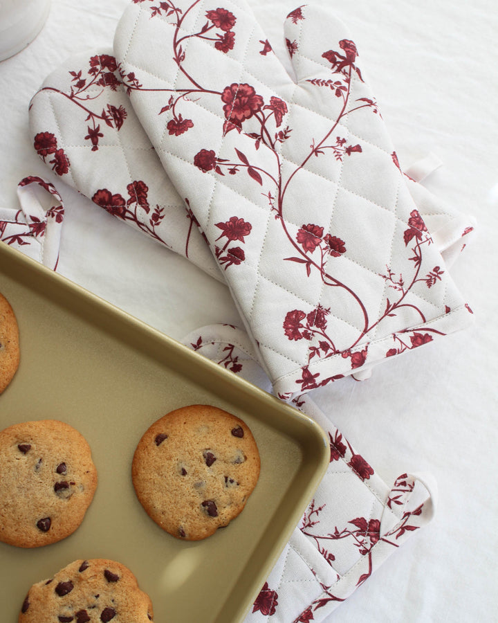 Perfect for the grandmillennial home, these red floral oven mitts feature a classic, feminine botanical print. The vibrant red blossoms add a sophisticated pop of color against neutral kitchen cabinets. These quilted cotton gloves are both functional and decorative, fitting seamlessly into a curated collection of floral linens. A timeless choice for anyone who loves the intersection of traditional style and modern organic quality.