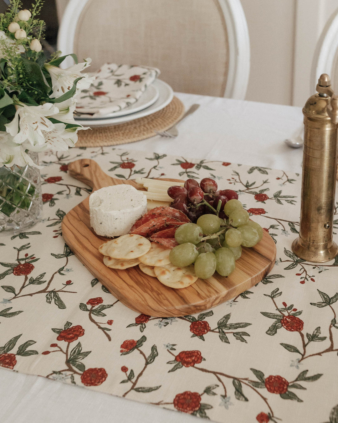 Beautiful William Morris inspired floral table runner featuring an intricate hand-drawn design of charming red flowers and lush green leaves with subtle blue accents. Available in extra-long 104-inch and 120-inch lengths, it is perfect for those who love Grandmillennial and maximalist decor. Crafted with non-toxic dyes, it’s a high-end, artistic addition to any spring tablescape.