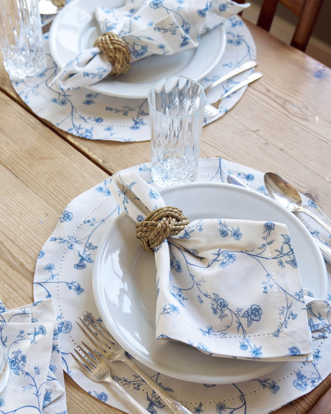 Elegant blue floral cotton placemats styled for a summer table, featuring a timeless hand-drawn print for hosting and gatherings