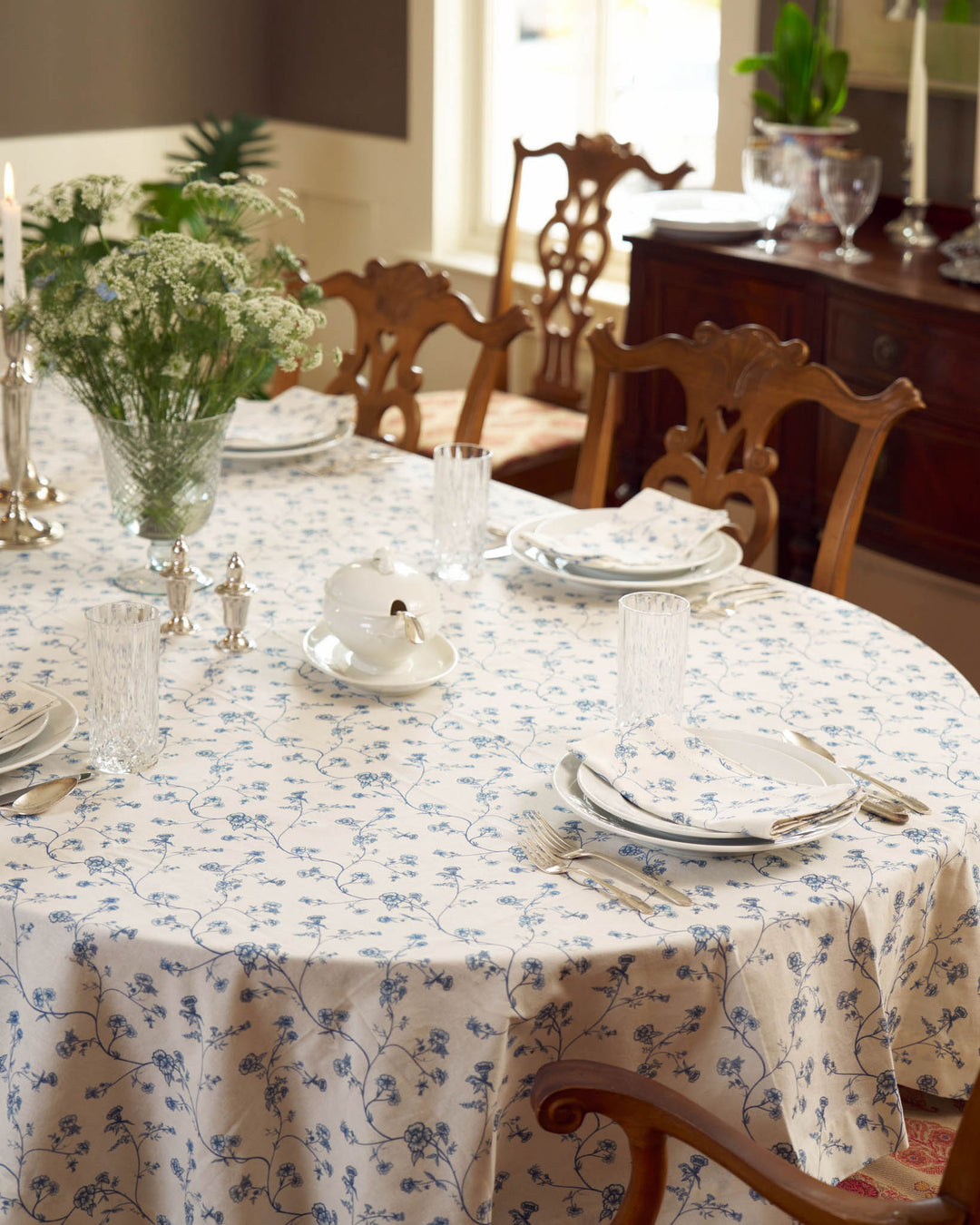 Garden Vine cotton tablecloth in a hand-drawn blue and white floral Charleston print, styled for a summer table with coastal grandmother charm.