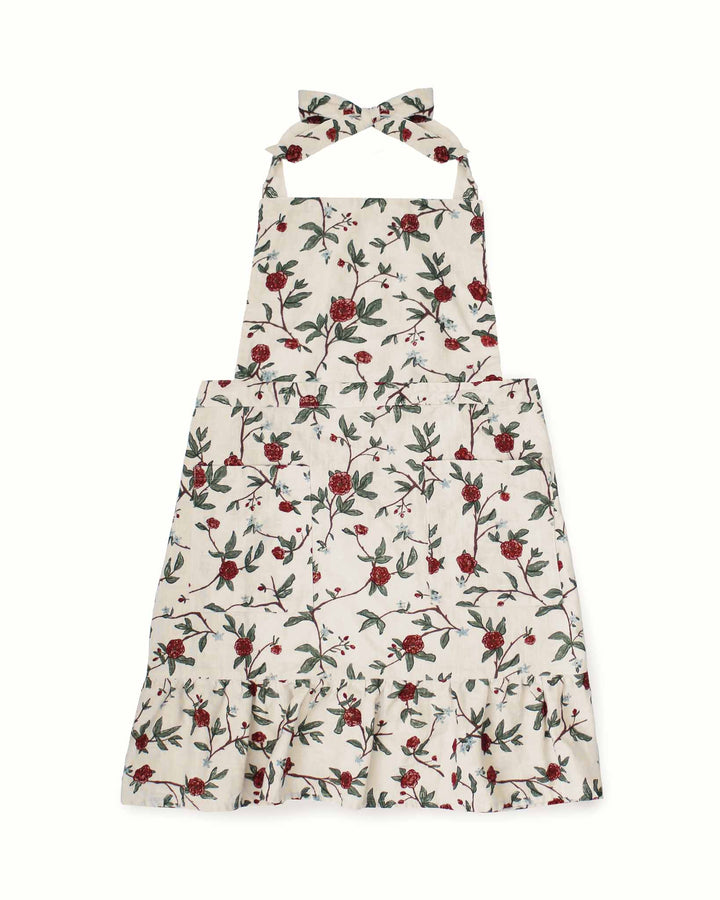 A vibrant red and green floral smock apron dress featuring an exquisite botanical print and a playful ruffle hem. This 100% cotton baking apron for women includes two practical pockets and adjustable ties for a custom fit. Designed for grand millennial decor, it serves as a beautiful ruffle cooking apron or gardening apron. An ideal Mother's Day gift for mom and daughter to wear while hosting a spring brunch or preparing festive Easter baking meals in a country kitchen.