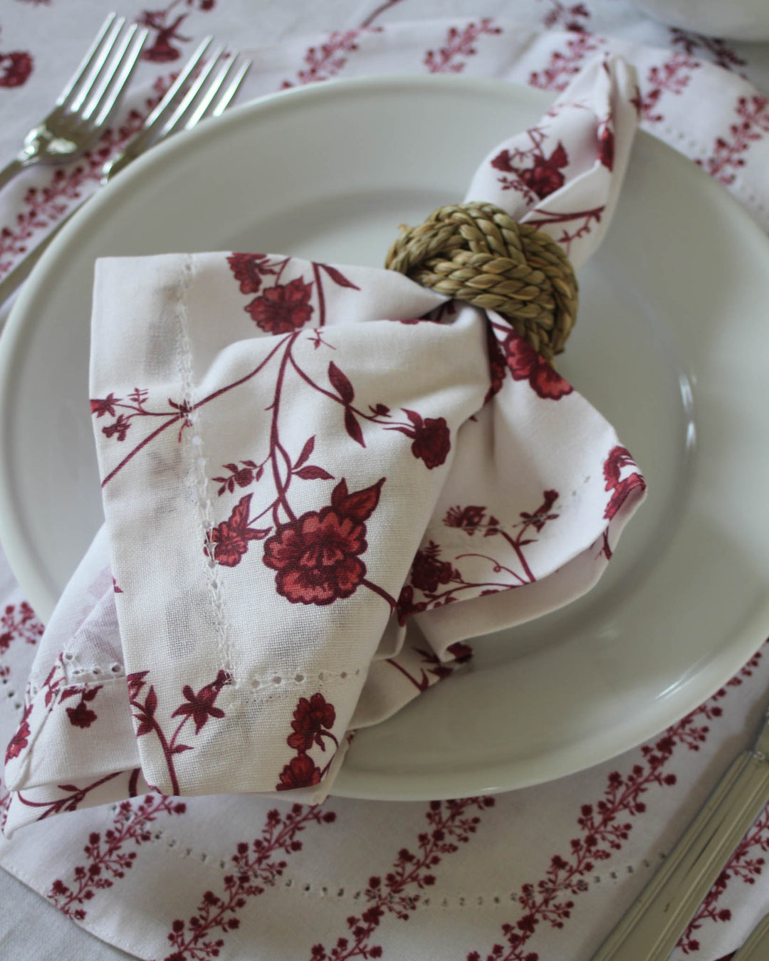 Embrace a storied, vintage look with these heritage-inspired red botanical napkins. Sold as a set of 4, these cotton table napkins feature a continuous pattern of red petals and vines on a crisp white background. They are designed to be true heirlooms, measuring 20x20 inches and offering versatility for country table decor or grand millennial home styling. Pair with our coordinating floral linens to turn your dinner table into a place of celebration, perfect for Christmas or a romantic anniversary.