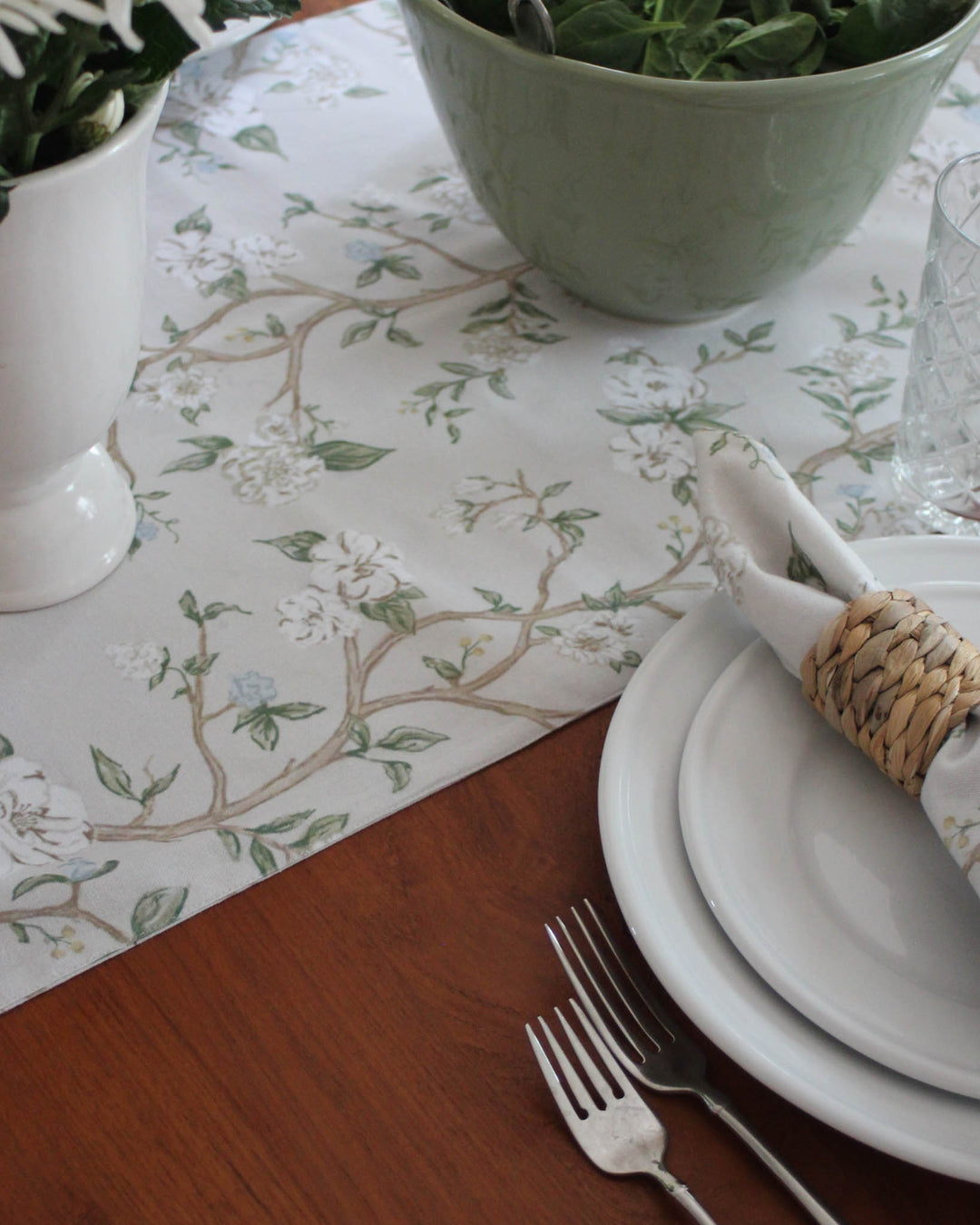This grandmillennial-style Chinoiserie table runner features an intricate hand-drawn botanical print in blue and green. Ideal for creating a curated, traditional tablescape for Easter or Mother’s Day brunch. Made from 100% organic cotton, it offers the perfect blend of heritage style and modern quality. The subtle background highlights the detailed floral artistry, making it a focal point of your dining room. A sophisticated choice for those who appreciate fine, hand-drawn textiles.