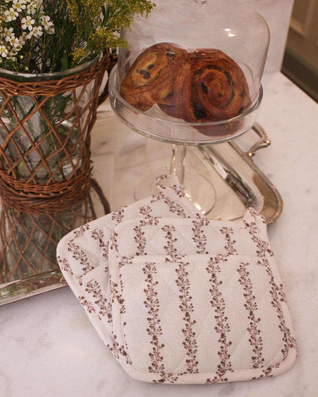 Practical and stylish, these chestnut brown floral stripe quilted cotton potholders are perfect for handling hot pans. This set of 2 woven potholders is made from premium cotton with recycled insulation for safe cooking. Each 8 inch square pad includes a loop for hanging. Use them as floral hot pads or quilted trivets for your Mother's Day brunch table. These are a wonderful grandma gift or gift for her this spring. Add these country kitchen accessories for your Easter baking set.