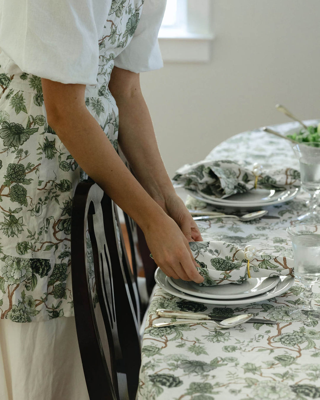 Soft green floral cotton tablecloth and napkins styled for a summer tablescape, perfect for hosting and seasonal gatherings