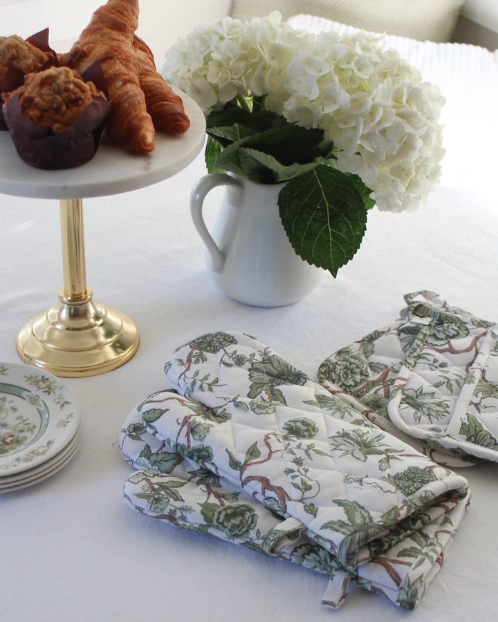 Green floral oven mitt set in cotton, designed for safely handling hot dishes, baking, and everyday use in the kitchen.