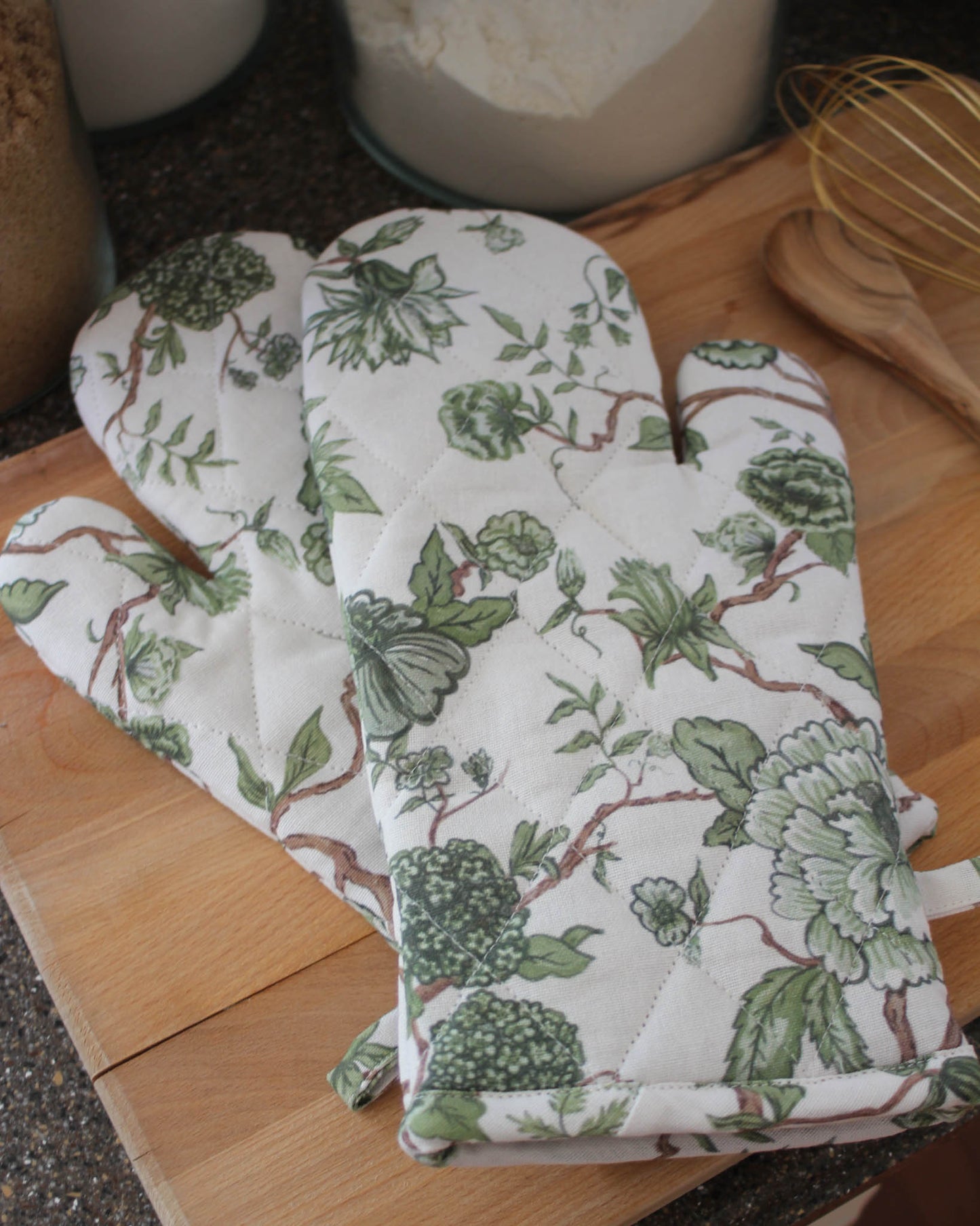 Green floral patterned oven mitts with quilted stitching