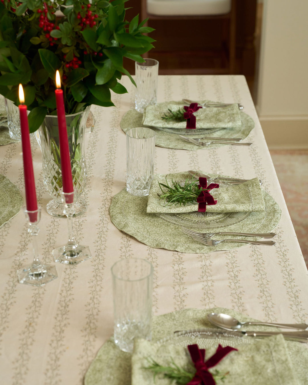 Beautiful sage green floral placemats styled for a classic Christmas tablescape with timeless holiday table linens.