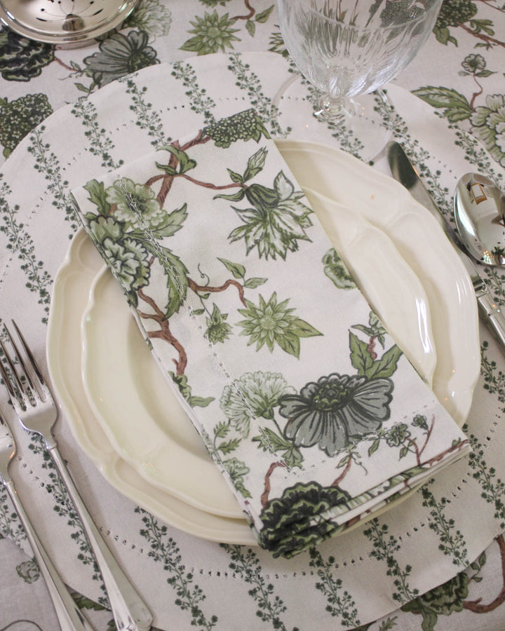 Coordinated green floral cotton table linens including napkins and tablecloth, ideal for summer hosting and outdoor meals
