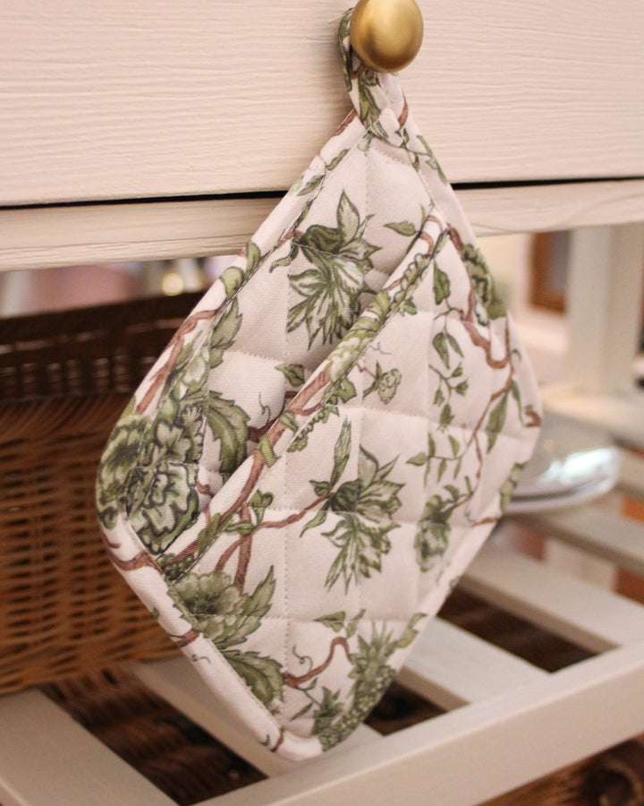 This green fern floral potholder set of 2 brings functionality to your spring kitchen. Made of premium cotton with recycled insulation, these quilted hot pads are designed for safe handling of hot trays. Each 8x8 woven potholder includes a loop for hanging. Ideal as quilted trivets for a Mother's Day brunch or floral hot pads for Easter baking. A perfect gift for her, mom, or grandma, these country kitchen accessories embody grand millennial decor with a timeless botanical print.