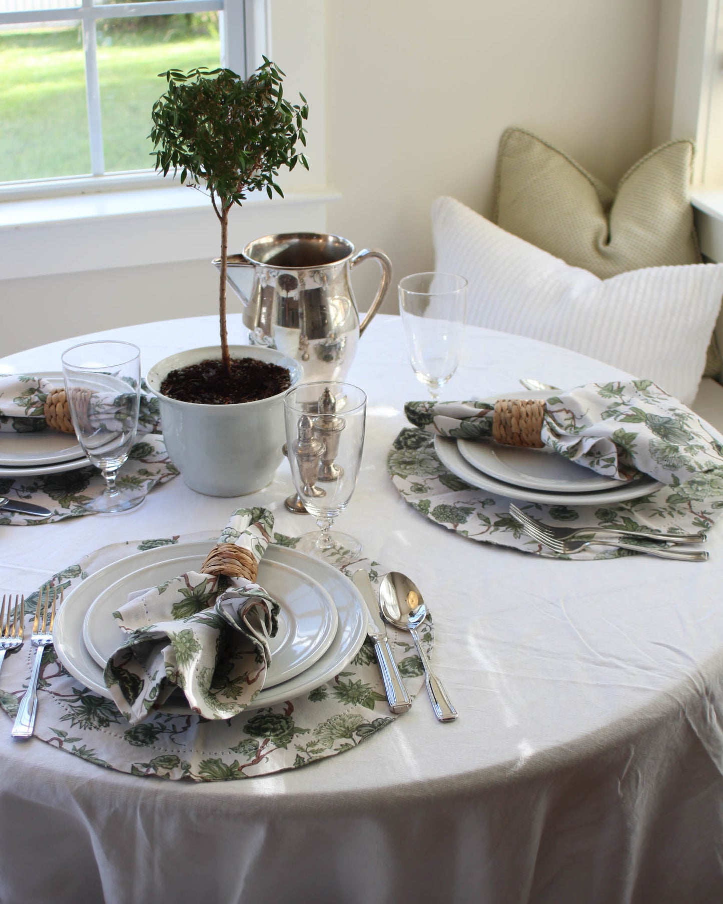 Elegant green floral table setting with silverware, plates, and decorative elements for fall hosting.