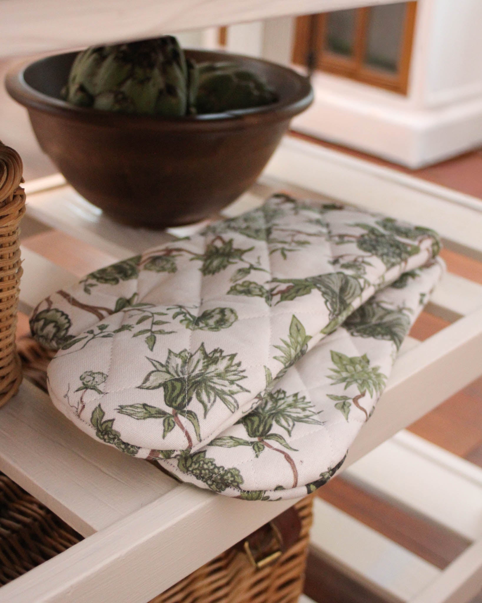 Quilted cotton oven mitt pair in floral print, durable and insulated for cooking, baking, and holiday entertaining.