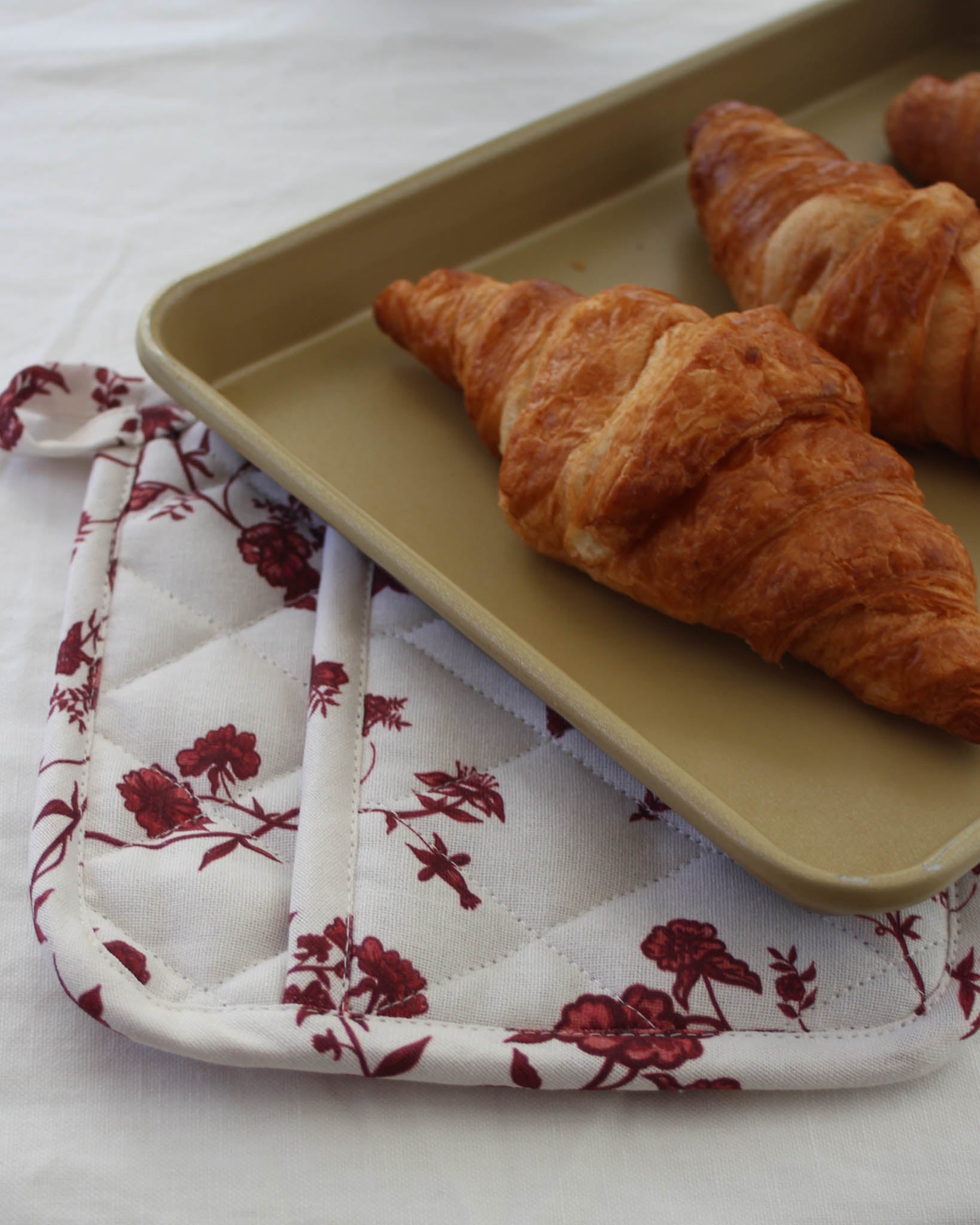 Hand-drawn floral print pot holders that add charm to cooking and make a lovely housewarming gift.