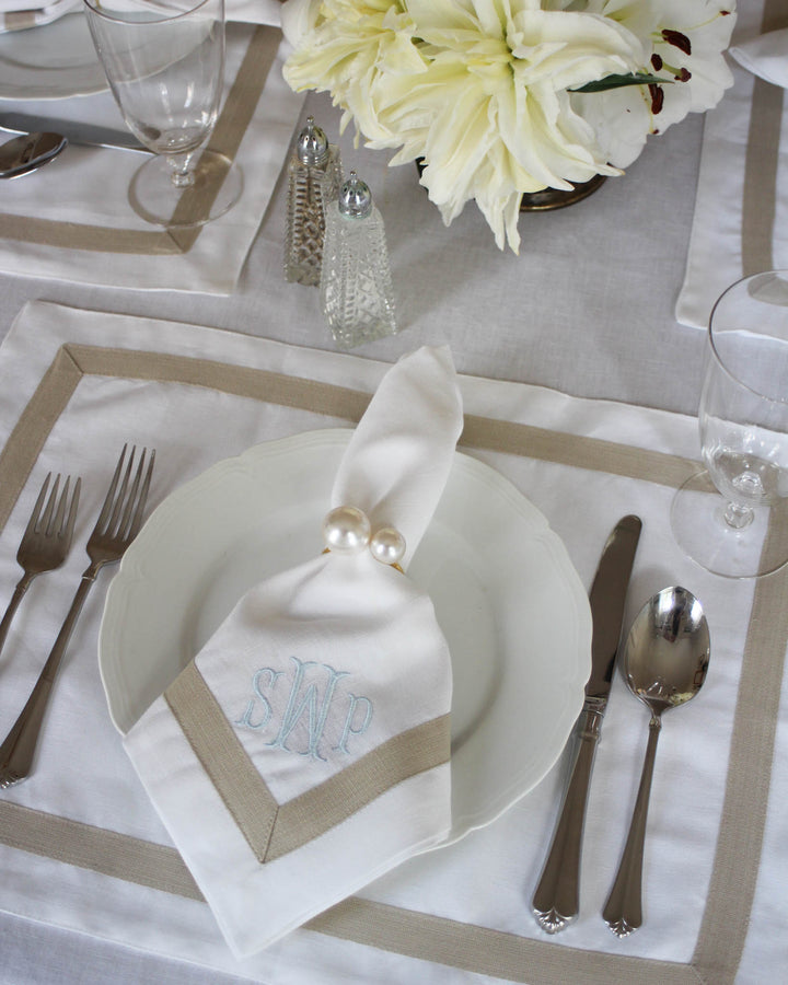 Add elegance to your wedding table with our set of four personalized white napkins with beige trim. Made from soft, high-quality cotton (20”x20”), they feature an embroidered monogram, perfect for a timeless, sophisticated touch to your reception.
