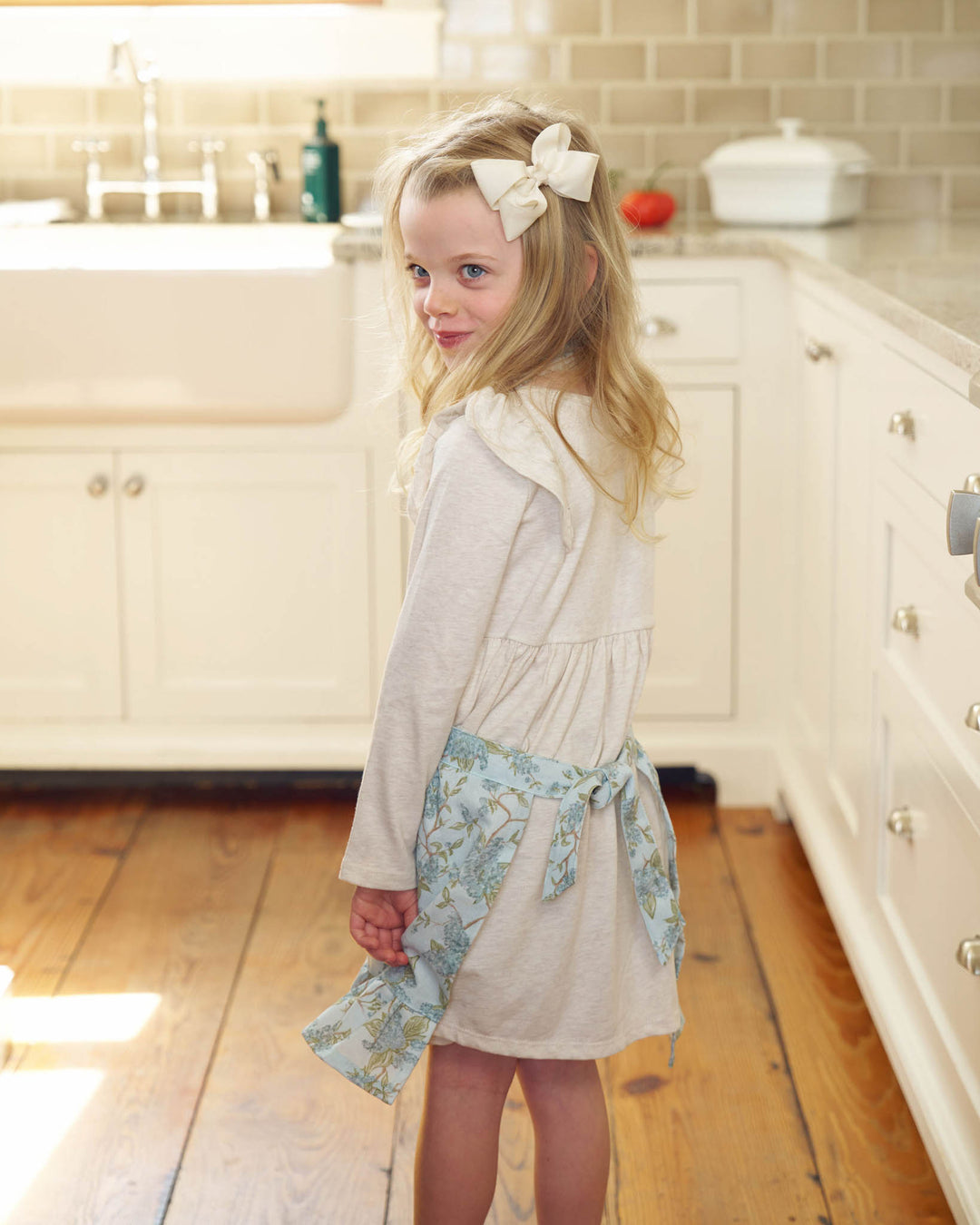 Little girl wearing a blue hydrangea cotton apron