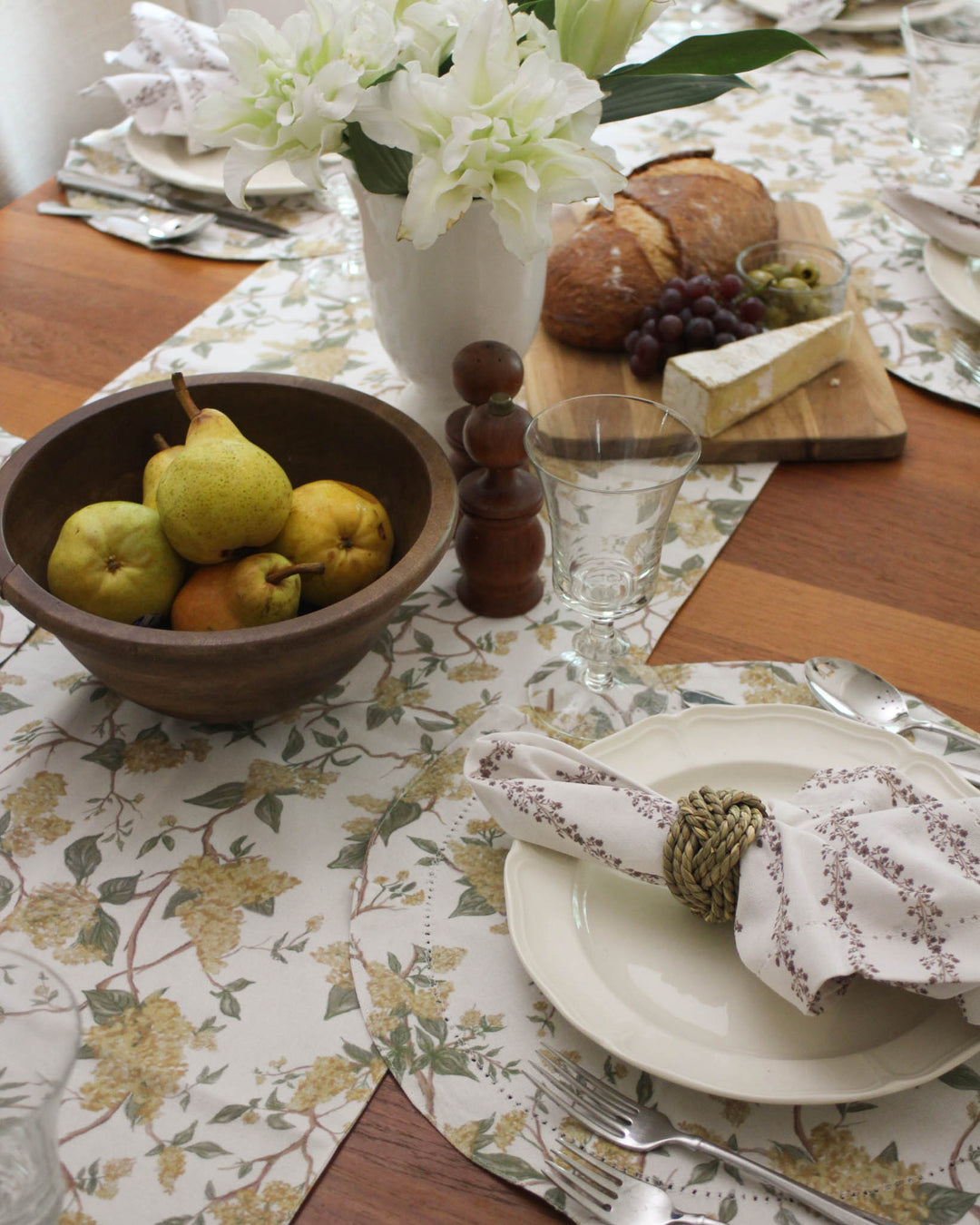 Charming spring floral table runner with a hand-drawn design of yellow blossoms and green foliage. This modern and elegant runner is a must-have for summer garden parties, outdoor weddings, and bridal showers. The 100% cotton material is dyed using non-toxic methods, ensuring a safe and beautiful setting for your guests. Pair with coordinating linens to create a seamless, botanical-inspired look. Versatile enough for farmhouse decor or a more sophisticated, formal table arrangement.
