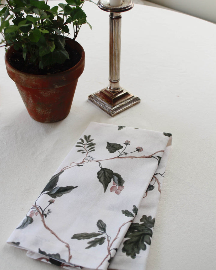Neutral botanical cotton tea towel featuring a delicate hand-drawn floral print, perfect for Christmas kitchen decor and holiday baking.