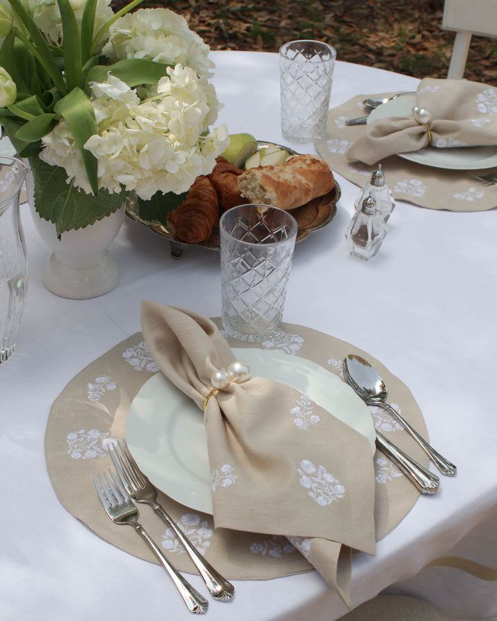 Set of 4 classic round placemats in a neutral beige color, featuring delicate white floral embroidery. Perfect for Mother's Day, spring, and summer tablescapes, these timeless placemats add charm and sophistication to any dining setting.