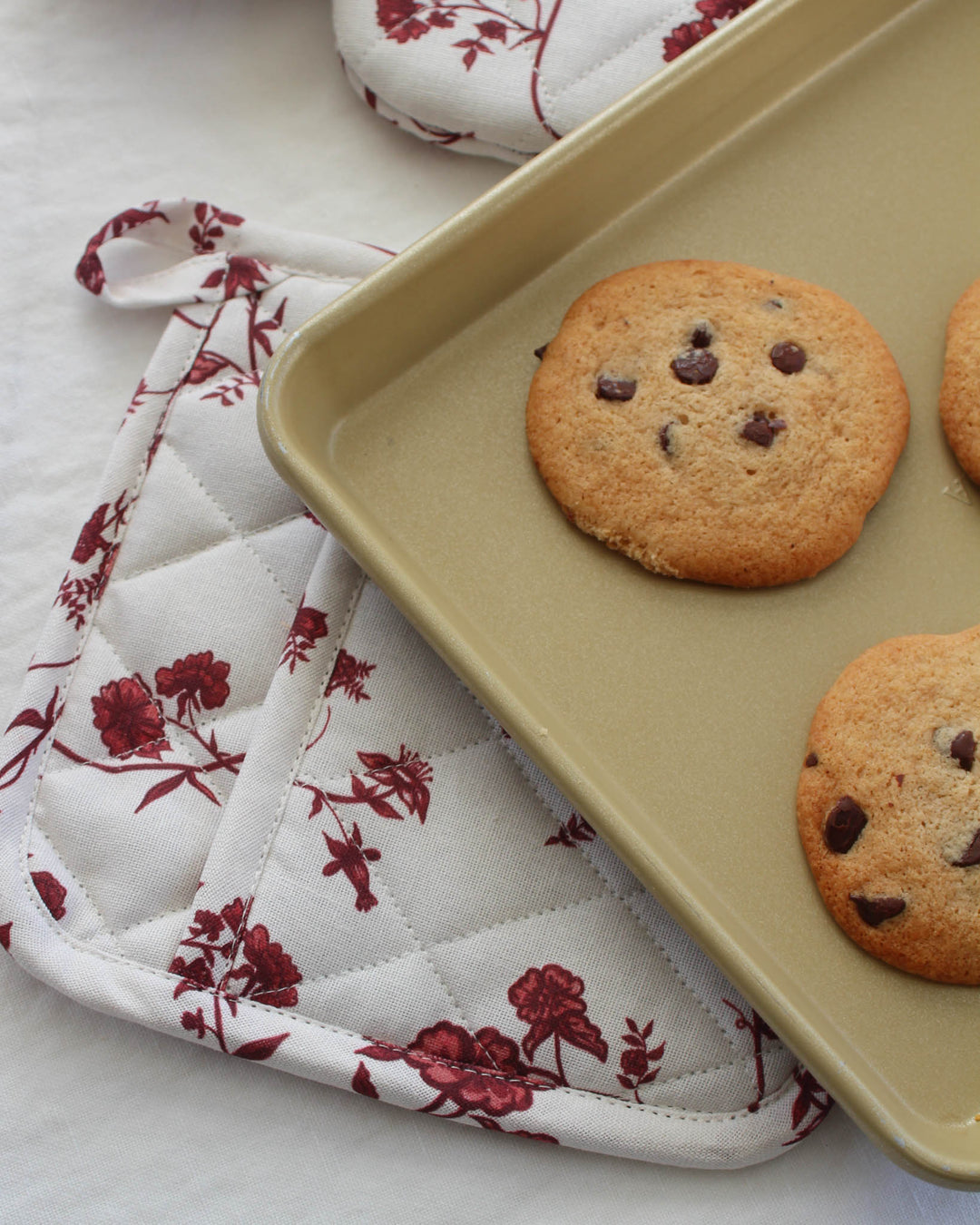 Elevate your spring hosting with these red botanical floral quilted hot pads. This set of two 8-inch square potholders is made from premium cotton, providing excellent heat insulation for hot pots and pans. Use them as decorative trivets on your dining table or as functional pot holders for baking. The intricate diamond quilting and classic floral pattern make them a beautiful Mother's Day or Easter gift. These charming red floral potholders bring practical elegance to any kitchen.
