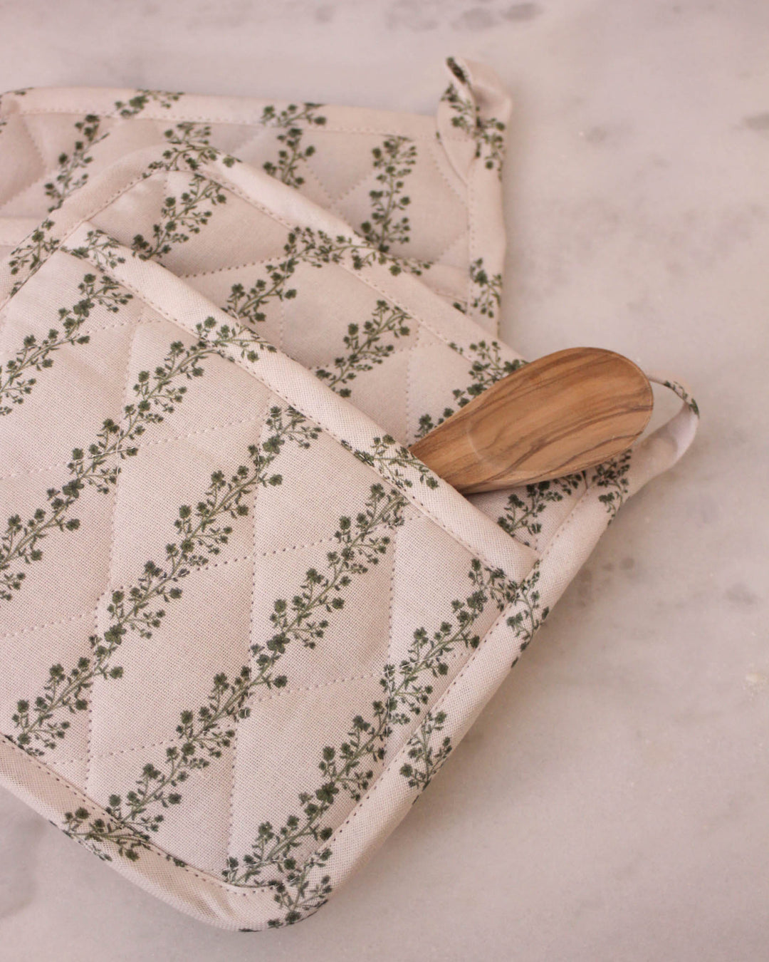 A set of two green floral stripe quilted cotton potholders with a vintage botanical and striped print, perfect for grand millennial decor. These 8 inch square quilted potholders for baking and cooking are made from premium cotton with thick recycled cotton insulation for safe handling of hot dishes and pans. Each woven potholder features a convenient hanging loop. Use them as quilted hot pads or floral hot pads to protect surfaces during Easter baking or a Mother's Day brunch.