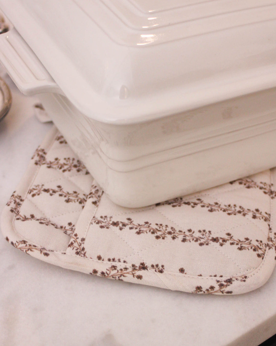 Beautifully crafted chestnut brown floral stripe quilted cotton woven potholder set. This set of 2 pot holders is made from premium cotton with recycled cotton insulation, making them perfect quilted potholders for baking and cooking. Each 8 inch square pad includes a hanging loop. Ideal as floral hot pads or quilted trivets for protecting surfaces. These spring kitchen essentials are a great gift for her, mom, or a grandma gift. Perfectly complements grand millennial decor style.