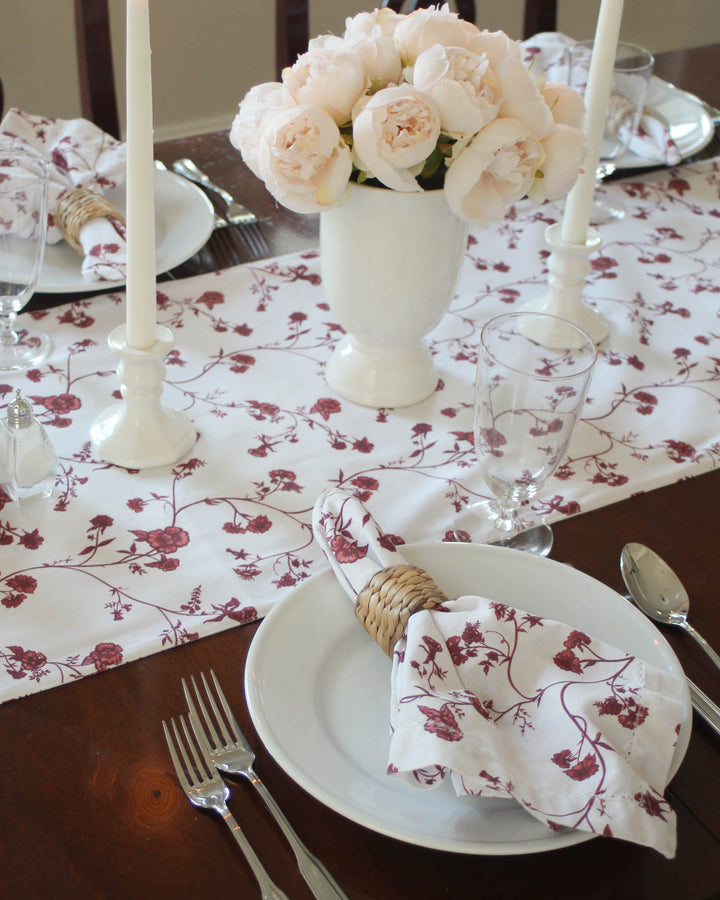 Elevate your Easter home decor with this beautiful red floral table runner. The delightful design of hand-drawn red flowers and lush leaves is perfect for holiday hosting and festive spring gatherings. Crafted from 100% cotton with non-toxic dyes, it adds an elegant, vibrant touch to your tablescape. Available in two generous lengths to fit long dining tables. Ideal for creating a warm, inviting atmosphere for Easter lunch or a sophisticated Mother's Day brunch.