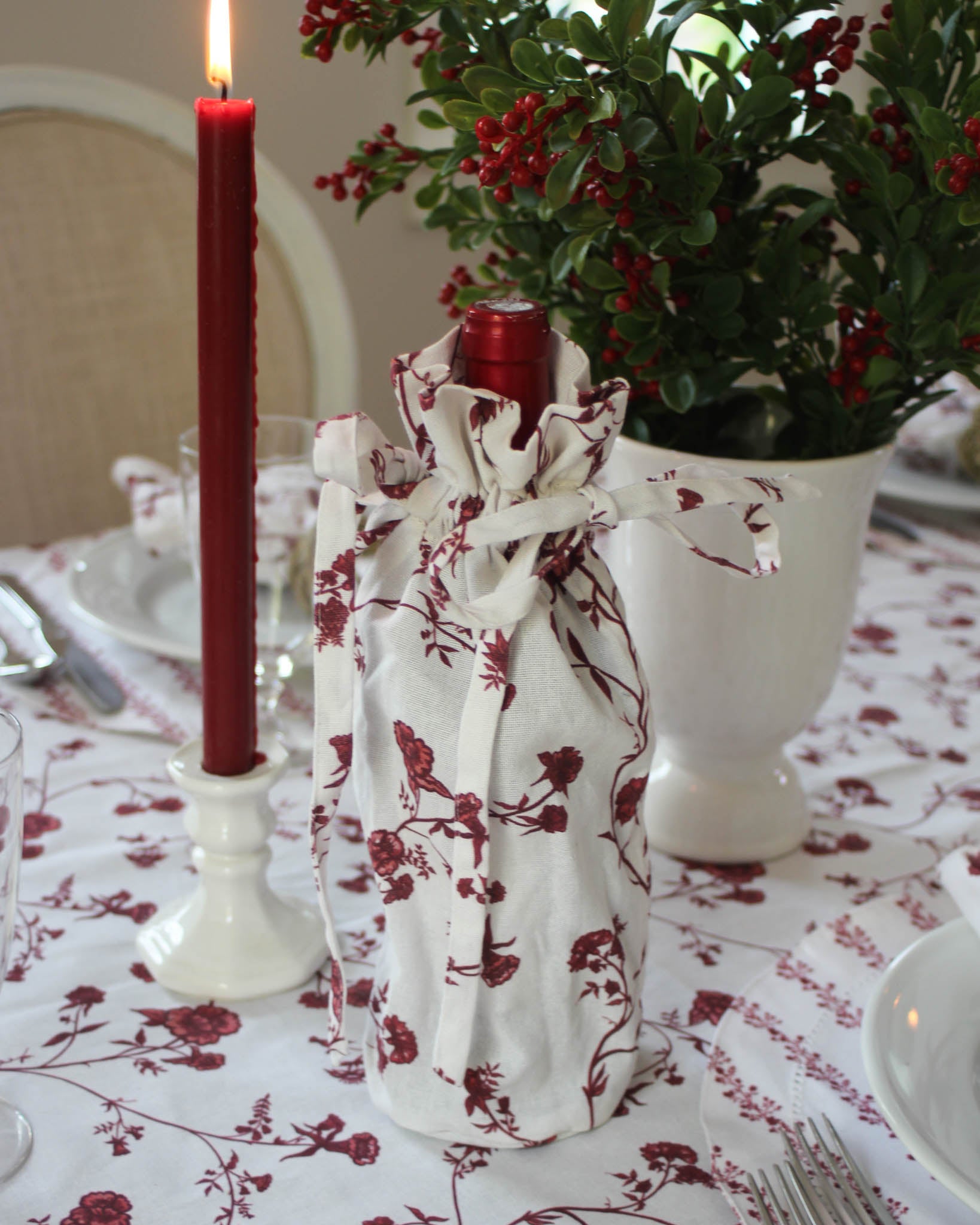 Elegant reusable wine gift bag in red floral design, perfect for hostess gifts and holiday celebrations.