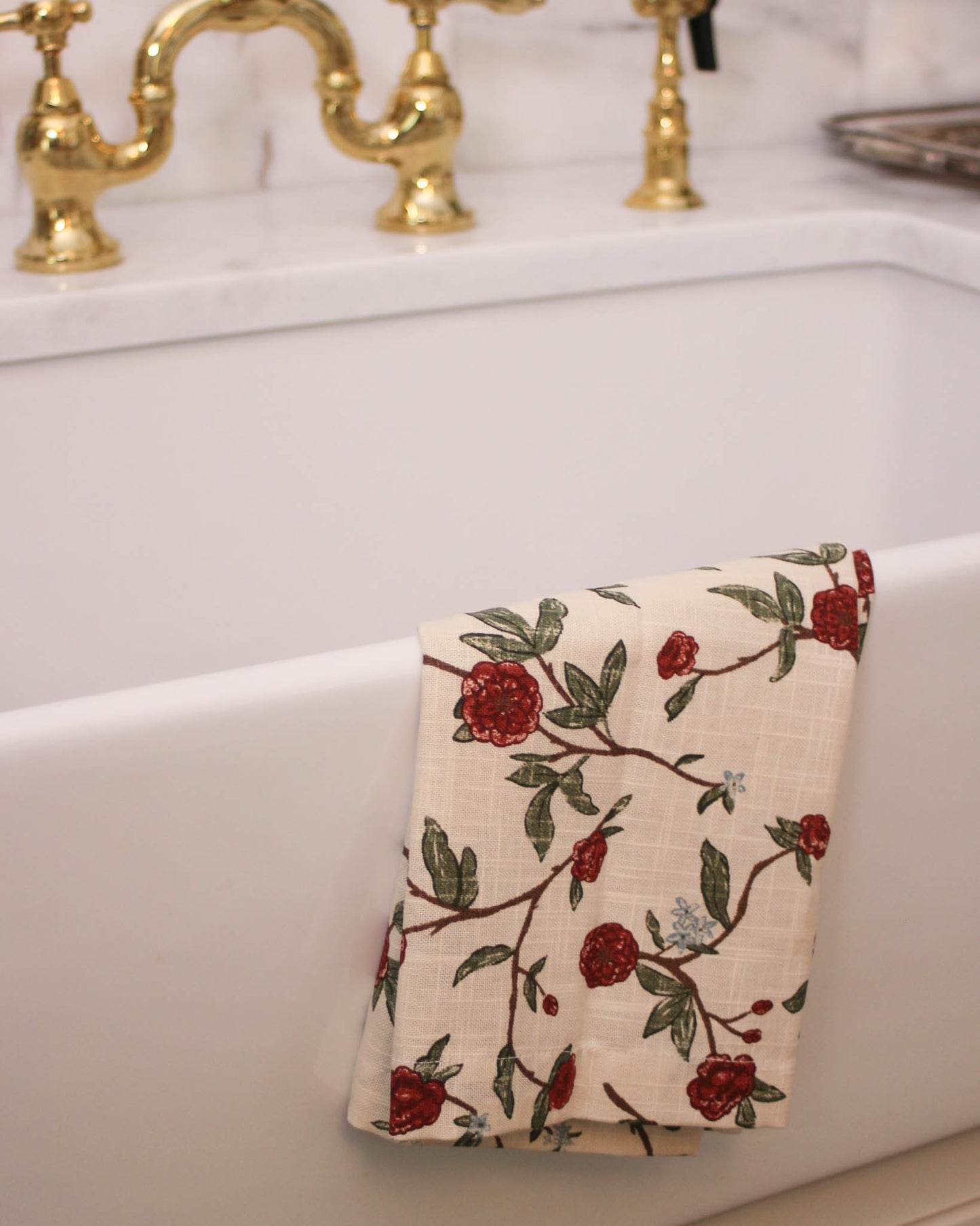 Red floral organic cotton tea towel for Christmas kitchen. Hand-painted design, hanging loop. Perfect holiday hostess gift or stocking stuffer. Made ethically.