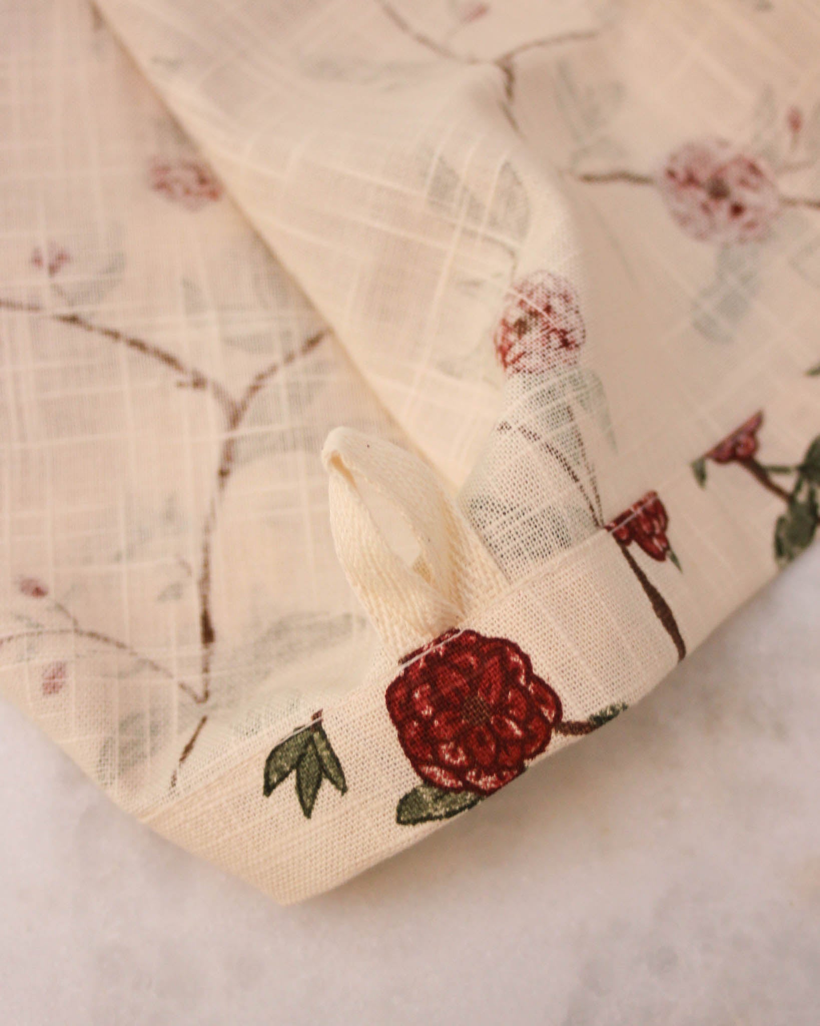 Hand-painted red floral tea towel in soft organic cotton. Hanging loop for display. Thoughtful Christmas gift for cooks who love festive kitchen style.