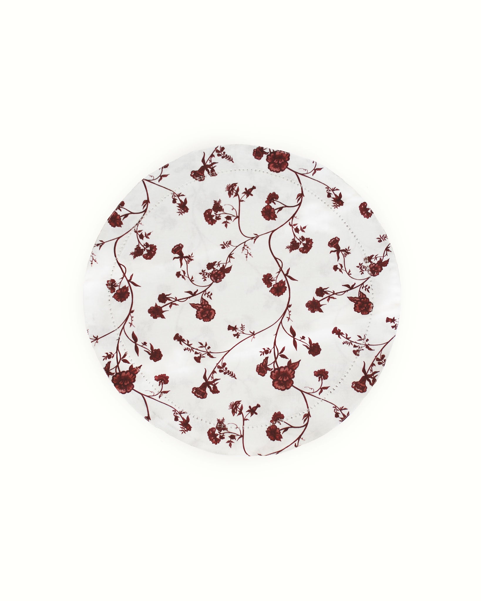 Round red floral table placemats, woven from organic cotton and crafted ethically in India.
