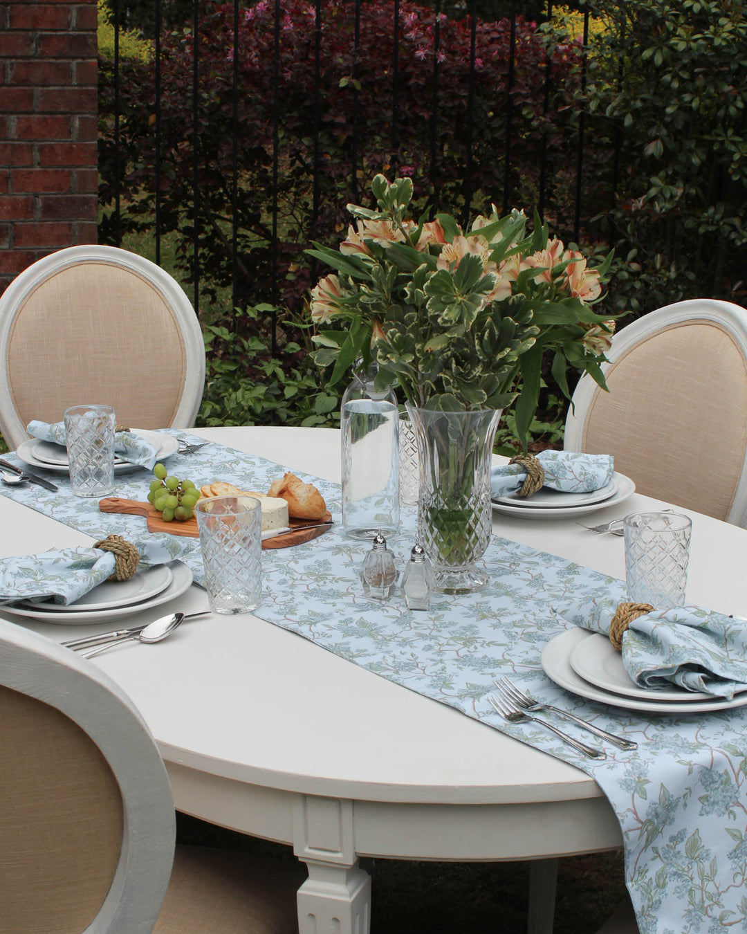 Bring the beauty of Charleston gardens to your home with this "Charleston blue" floral table runner. The hand-drawn botanical design is printed on a subtle background with hints of green, creating a peaceful and inviting layer for your table. Ideal for Easter table decor, Mother’s Day brunch, or daily summer meals. Durable and machine-washable, this 100% cotton runner is designed for real-life hosting while maintaining a polished, high-end look for your family and guests.