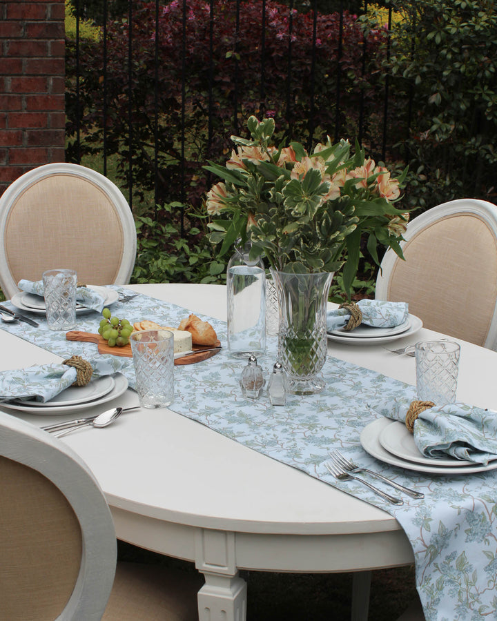 Bring the beauty of Charleston gardens to your home with this "Charleston blue" floral table runner. The hand-drawn botanical design is printed on a subtle background with hints of green, creating a peaceful and inviting layer for your table. Ideal for Easter table decor, Mother’s Day brunch, or daily summer meals. Durable and machine-washable, this 100% cotton runner is designed for real-life hosting while maintaining a polished, high-end look for your family and guests.