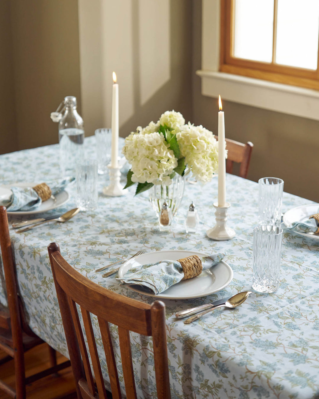 Easter table set with a blue hydrangea floral cotton tablecloth and coordinating linens.