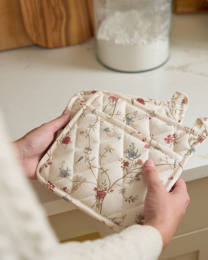Antique-inspired floral cotton pot holders designed to protect hands and surfaces while cooking, baking, serving hot dishes, preparing homemade recipes, hosting dinner parties, celebrating Thanksgiving and Christmas, and gifting to bakers, hostesses, newlyweds, and new homeowners.