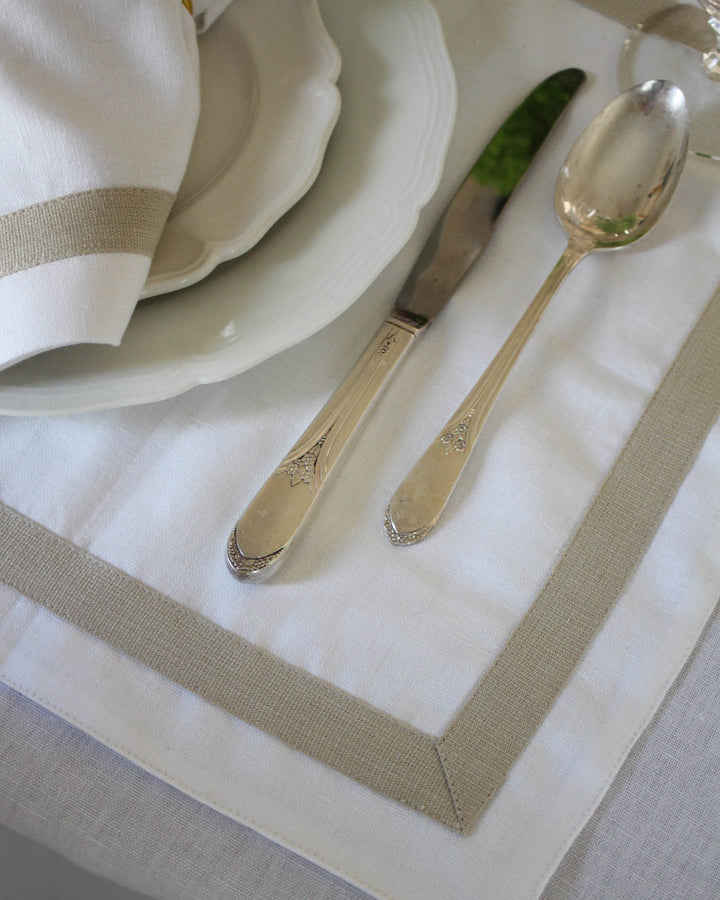 White cotton linen placemats featuring a tailored border detail, woven from organic cotton and linen for durability and softness. Sold as a set of four, these placemats are ideal for spring tables, Easter brunch, and elegant everyday meals. Designed to mix seamlessly with other linens, they suit grand millennial and French country decor and make thoughtful wedding gifts or heirloom-style hostess gifts.