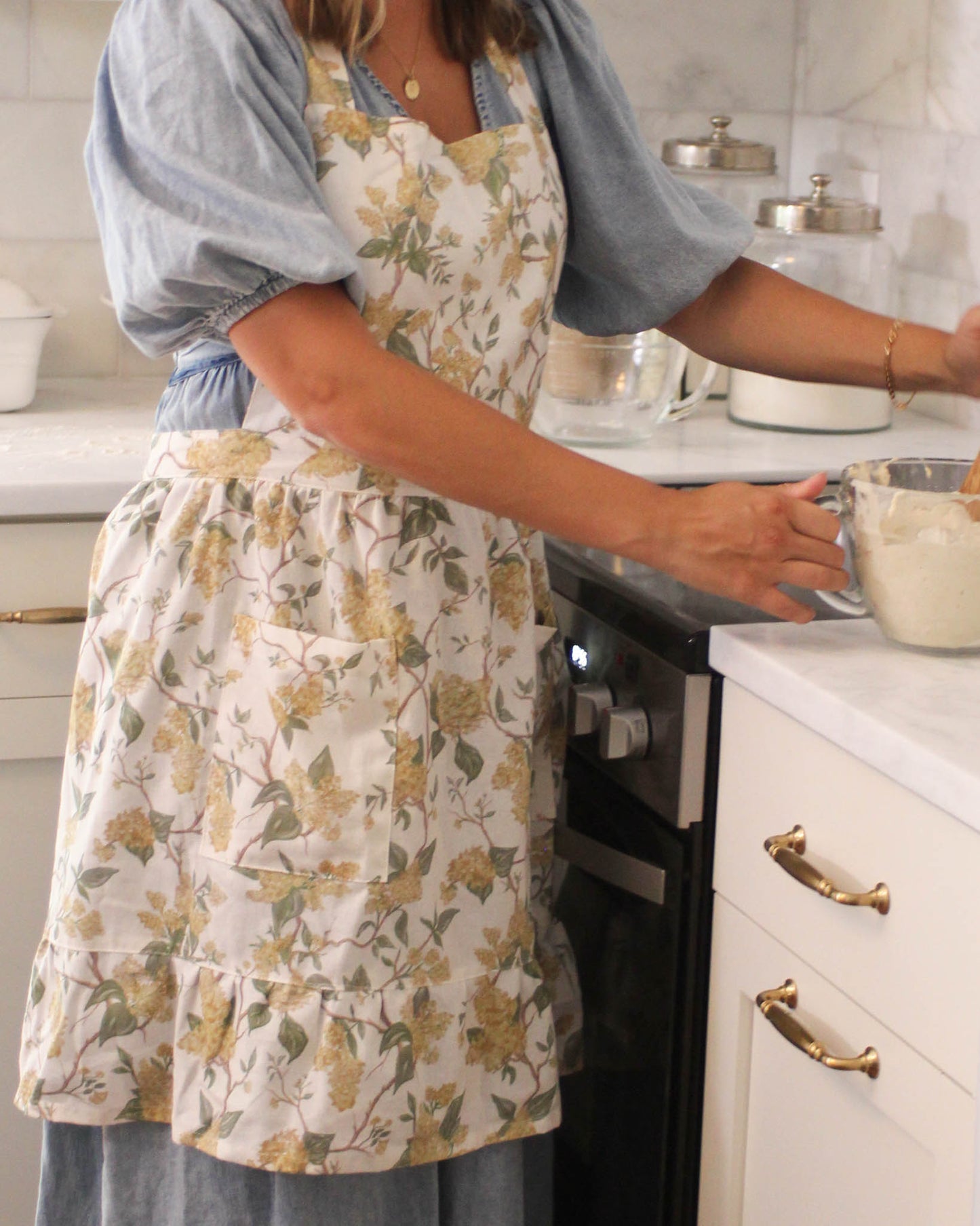 Women’s floral apron with ruffle hem and front pockets