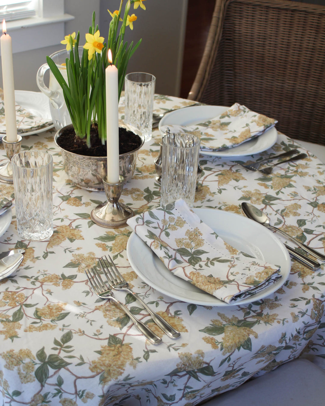Yellow floral cotton napkins styled on an Easter table with fresh flowers and elegant spring place settings.