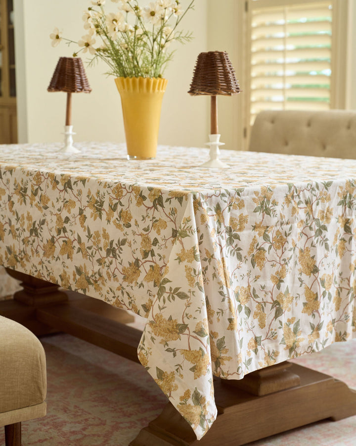 Warm yellow floral cotton tablecloth featuring a hand-drawn marigold-inspired print for elegant fall dining, seasonal entertaining, and classic Thanksgiving table settings.